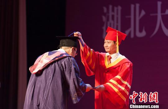 图为，必赢线路检测中心校长赵凌云为毕业生拨穗正冠 向正鹏 摄